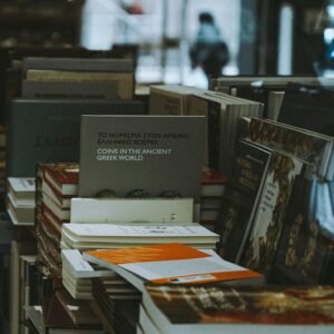 A collection of books stacked neatly on a bookstore shelf indoors.