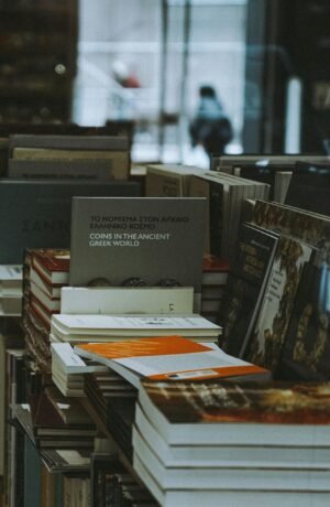 A collection of books stacked neatly on a bookstore shelf indoors.