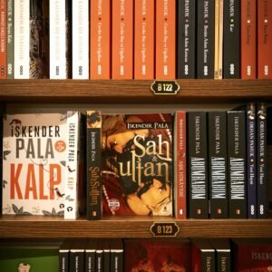 Bookshelf featuring various novels by author Iskender Pala in a bookstore.