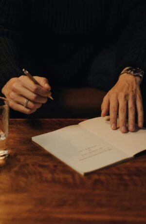 Man signing books during an intimate creative event in a cozy indoor setting.