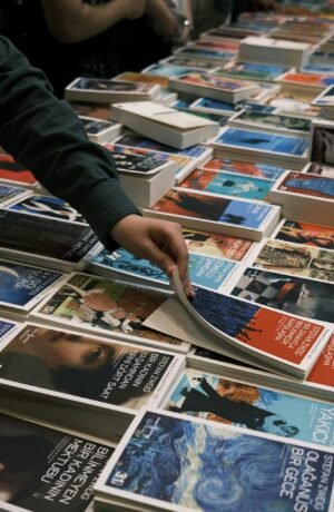 Person browsing books at a lively book sale in İzmit, Türkiye.