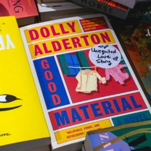 Vibrant mix of books on a shelf, highlighting 'Good Material' by Dolly Alderton.